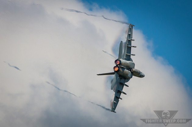 An F/A-18E Super Hornet pulls through a high-G turn during a simulated dogfight for the airshow crowd at NAS Oceana, Virginia.