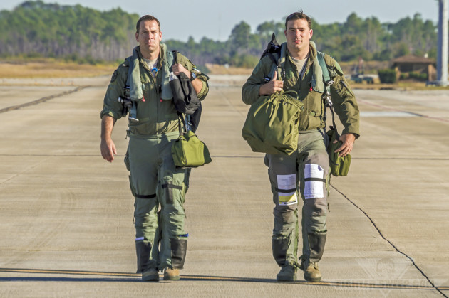 "Hypr" and "Ox," two F-16CJ pilots with the 55 FS (Roll 'Em!), walk back to briefing after returning from their training mission. Note both pilots are wearing the Advanced Technology Anti-G Suit (ATAGS).