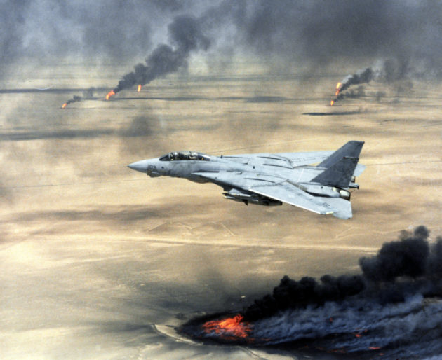 US Navy (USN) F-14A Tomcat, Fighter Squadron 211 (VF-211), Naval Air Station (NAS) Oceana, Virginia Beach, Virginia (VA), in flight over burning Kuwaiti oil wells during Operation DESERT STORM.